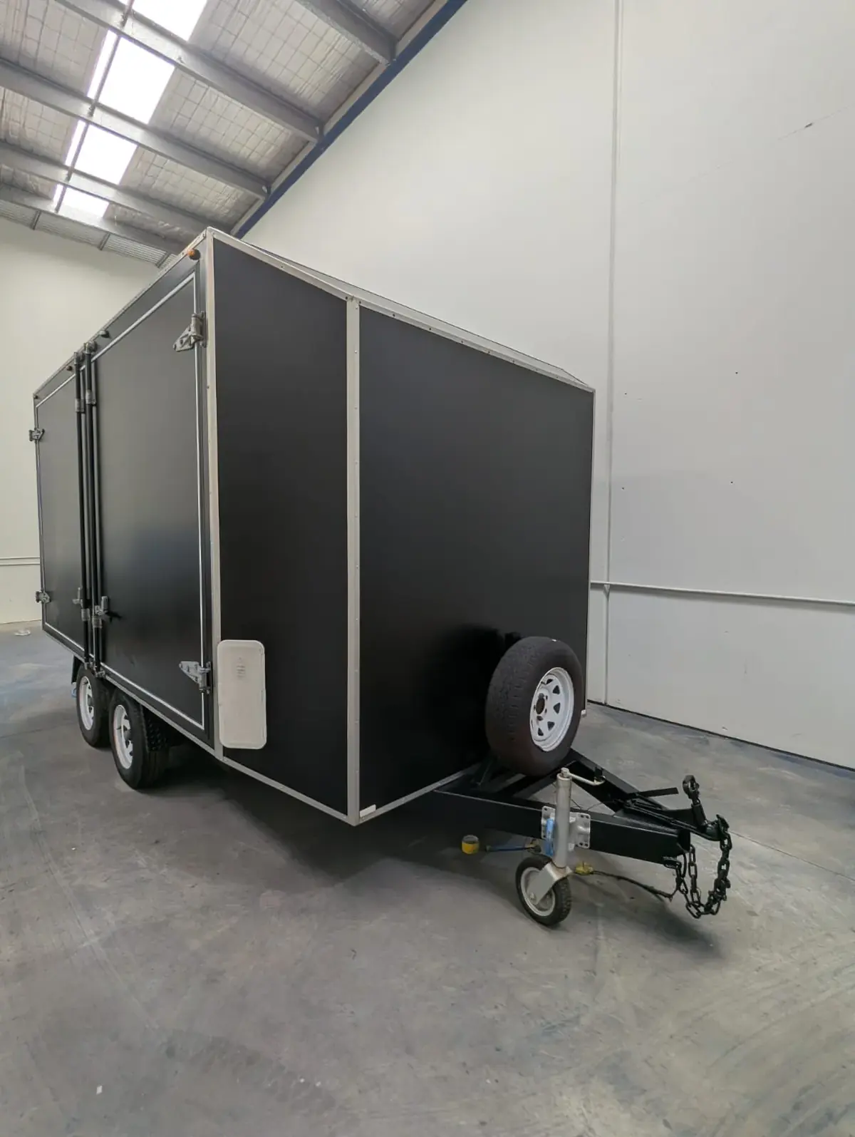 Enclosed box trailer finished in black inside the workshop